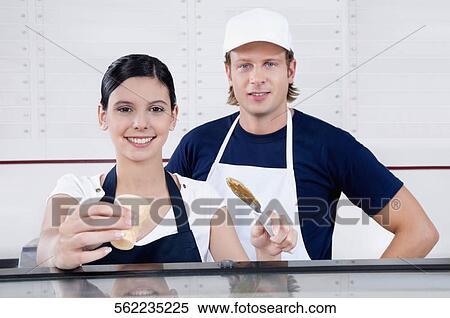 Sales clerks smiling in an ice cream parlor View Large Photo Image Stock Photography - Sales clerks smiling in an ice cream parlor. Fotosearch