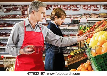 Salesman and a customer in a supermarket View Large Photo Image Stock Photo - Salesman and a customer in a supermarket. Fotosearch