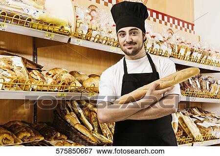 Salesman holding a loaf of bread in a supermarket View Large Photo Image Stock Photo - Salesman holding a loaf of bread in a supermarket. Fotosearch