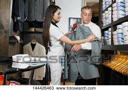 Saleswoman assisting a businessman in a clothing store View Large Photo Image Stock Image - Saleswoman assisting a businessman in a clothing store. Fotosearch