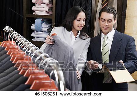 Saleswoman assisting a businessman in a clothing store View Large Photo Image Stock Image - Saleswoman assisting a businessman in a clothing store. Fotosearch