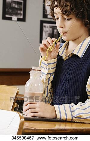 Schoolboy drinking chocolate milkshake in a classroom View Large Photo Image Stock Photo - Schoolboy drinking chocolate milkshake in a classroom. Fotosearch