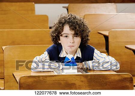 Schoolboy drinking juice in a classroom View Large Photo Image Stock Photo - Schoolboy drinking juice in a classroom. Fotosearch