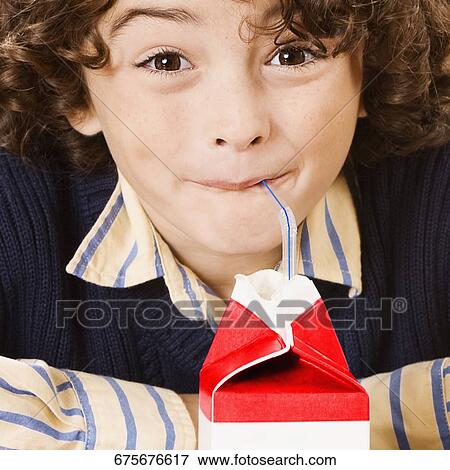 Stock Photo - Schoolboy drinking juice in a classroom. Fotosearch