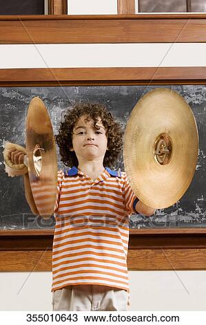 Schoolboy playing cymbals in a classroom View Large Photo Image Stock Image - Schoolboy playing cymbals in a classroom. Fotosearch