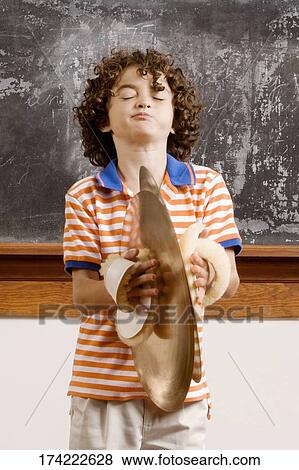 Schoolboy playing cymbals in a classroom View Large Photo Image Stock Photo - Schoolboy playing cymbals in a classroom. Fotosearch