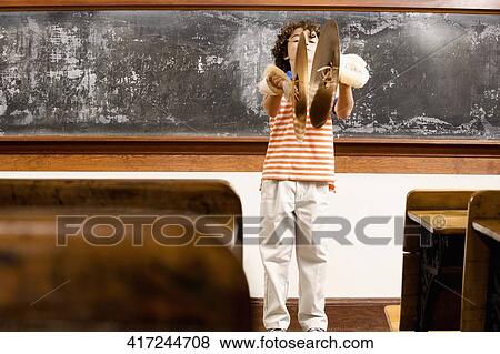 Stock Photo - Schoolboy playing cymbals in a classroom. Fotosearch