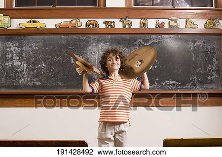 Schoolboy playing cymbals in front of a blackboard View Large Photo Image Stock Image - Schoolboy playing cymbals in front of a blackboard. Fotosearch