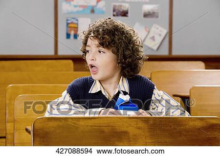 Schoolboy sitting in a classroom View Large Photo Image Picture - Schoolboy sitting in a classroom. Fotosearch
