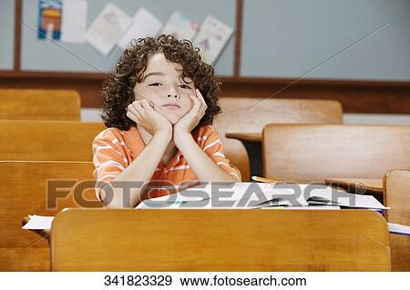 Schoolboy sitting in a classroom View Large Photo Image Stock Photo - Schoolboy sitting in a classroom. Fotosearch