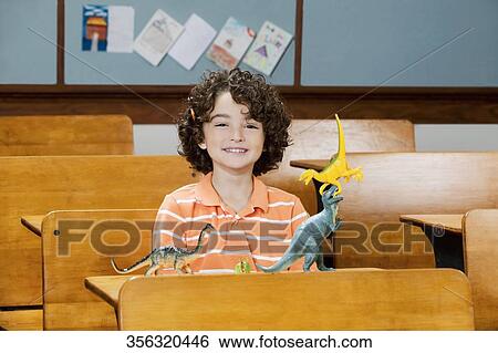 Schoolboy sitting in a classroom View Large Photo Image Stock Photograph - Schoolboy sitting in a classroom. Fotosearch