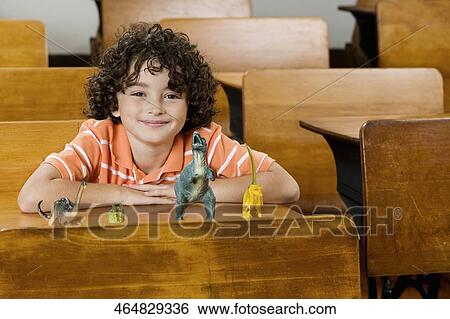 Stock Photograph - Schoolboy sitting in a classroom. Fotosearch