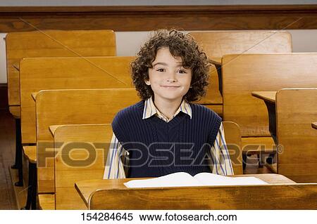 Schoolboy sitting in a classroom View Large Photo Image Stock Photography - Schoolboy sitting in a classroom. Fotosearch