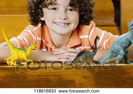 Stock Image - Schoolboy sitting with toys in a classroom. Fotosearch