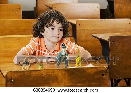 Schoolboy sitting with toys in a classroom View Large Photo Image Stock Image - Schoolboy sitting with toys in a classroom. Fotosearch