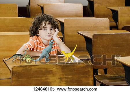Schoolboy sitting with toys in a classroom View Large Photo Image Stock Photography - Schoolboy sitting with toys in a classroom. Fotosearch