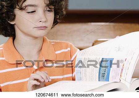 Schoolboy studying in a classroom View Large Photo Image Stock Image - Schoolboy studying in a classroom. Fotosearch