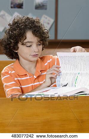 Stock Image - Schoolboy studying in a classroom. Fotosearch