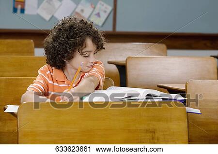 Schoolboy studying in a classroom View Large Photo Image Stock Image - Schoolboy studying in a classroom. Fotosearch