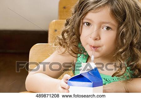 Schoolgirl drinking juice in a classroom View Large Photo Image Stock Photo - Schoolgirl drinking juice in a classroom. Fotosearch