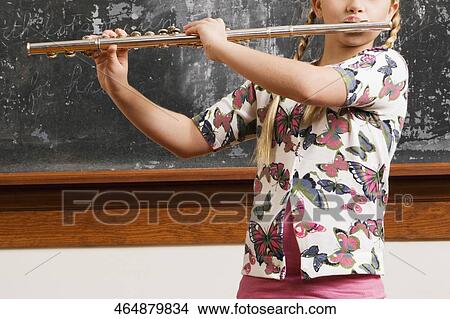 Schoolgirl playing a flute in a classroom View Large Photo Image Picture - Schoolgirl playing a flute in a classroom. Fotosearch