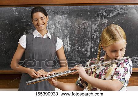 Schoolgirl playing a flute in a classroom View Large Photo Image Stock Image - Schoolgirl playing a flute in a classroom. Fotosearch
