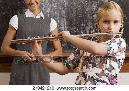Schoolgirl playing a flute in a classroom View Large Photo Image Stock Photo - Schoolgirl playing a flute in a classroom. Fotosearch