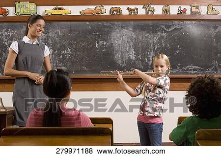 Schoolgirl playing a flute with her teacher and classmates in a classroom View Large Photo Image Stock Photo - Schoolgirl playing a flute with her teacher and classmates in a classroom. Fotosearch