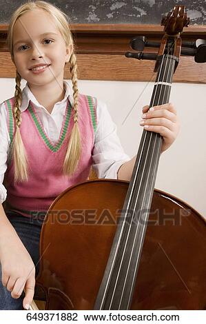 Schoolgirl playing a violin in a classroom View Large Photo Image Stock Image - Schoolgirl playing a violin in a classroom. Fotosearch