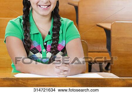 Picture - Schoolgirl sitting in a classroom. Fotosearch