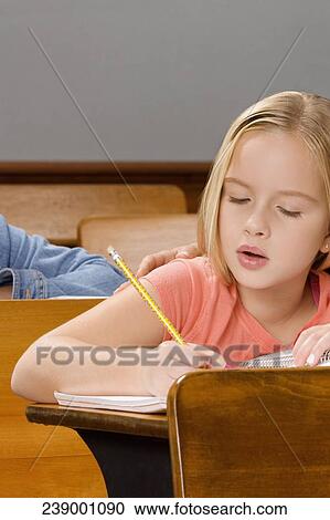 Schoolgirl studying in a classroom View Large Photo Image Stock Image - Schoolgirl studying in a classroom. Fotosearch