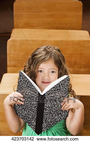 Stock Image - Schoolgirl studying in a classroom. Fotosearch