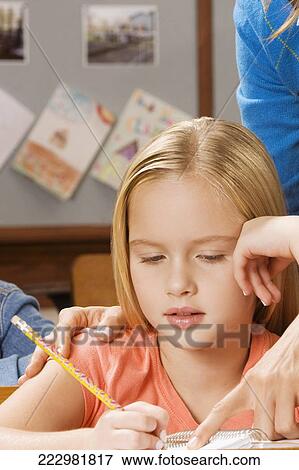 Schoolgirl studying in a classroom View Large Photo Image Stock Photo - Schoolgirl studying in a classroom. Fotosearch