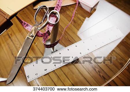 Scissors with a tape measure in a clothing design studio View Large Photo Image Stock Image - Scissors with a tape measure in a clothing design studio. Fotosearch
