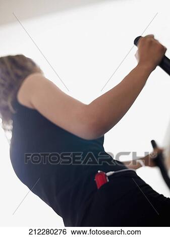 Stock Photograph - Side profile of a woman exercising and listening to music. Fotosearch