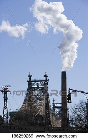 Smoke emerging from a chimney next to a bridge View Large Photo Image Stock Photo - Smoke emerging from a chimney next to a bridge. Fotosearch