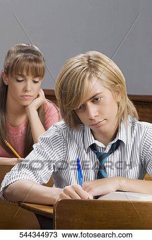 Students giving exam in a classroom View Large Photo Image Stock Image - Students giving exam in a classroom. Fotosearch