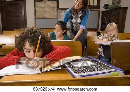 Students studying in a classroom with their teacher View Large Photo Image Picture - Students studying in a classroom with their teacher. Fotosearch