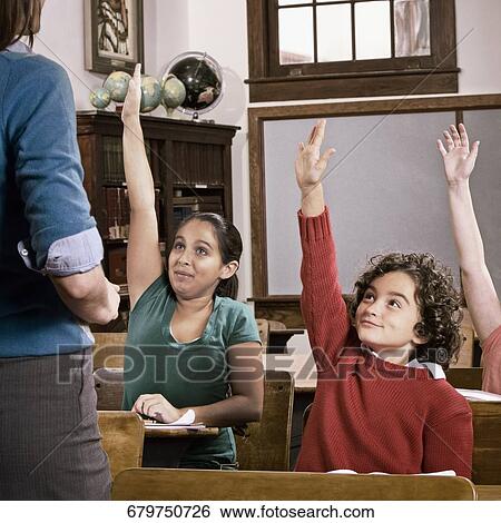 Stock Photograph - Students studying in a classroom with their teacher. Fotosearch