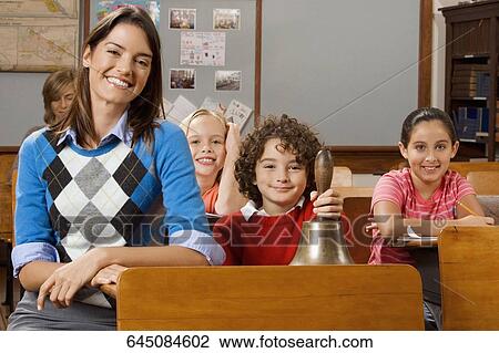 Stock Image - Students with their teacher in a classroom. Fotosearch