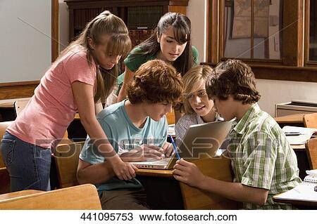 Stock Image - Students working on a laptop in the classroom. Fotosearch