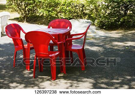 Tables and a chair in a garden View Large Photo Image Stock Photo - Tables and a chair in a garden. Fotosearch