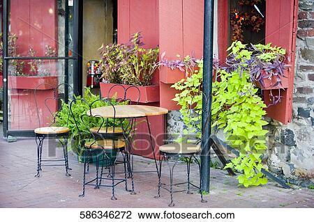 Stock Image - Tables and chairs outside a building. Fotosearch