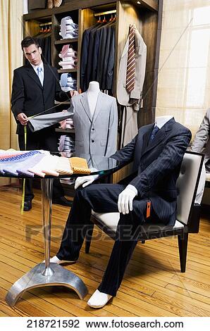 Tailor taking measurement in a clothing store View Large Photo Image Stock Image - Tailor taking measurement in a clothing store. Fotosearch