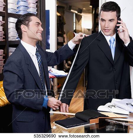 Tailor taking measurement of a businessman View Large Photo Image Stock Image - Tailor taking measurement of a businessman. Fotosearch