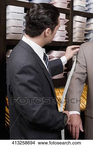 Tailor taking the measurements of a customer View Large Photo Image Picture - Tailor taking the measurements of a customer. Fotosearch