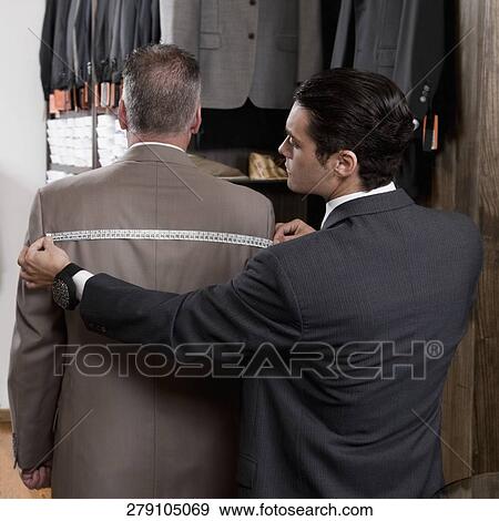 Tailor taking the measurements of a customer View Large Photo Image Stock Photo - Tailor taking the measurements of a customer. Fotosearch