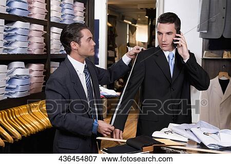Tailor taking the measurements of a customer View Large Photo Image Stock Photo - Tailor taking the measurements of a customer. Fotosearch
