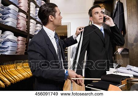 Tailor taking the measurements of a customer View Large Photo Image Stock Photo - Tailor taking the measurements of a customer. Fotosearch