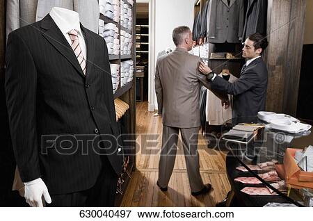 Tailor taking the measurements of a customer View Large Photo Image Stock Photo - Tailor taking the measurements of a customer. Fotosearch